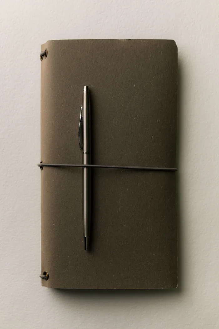 Un carnet fermé et un stylo, prêts pour faire le point.